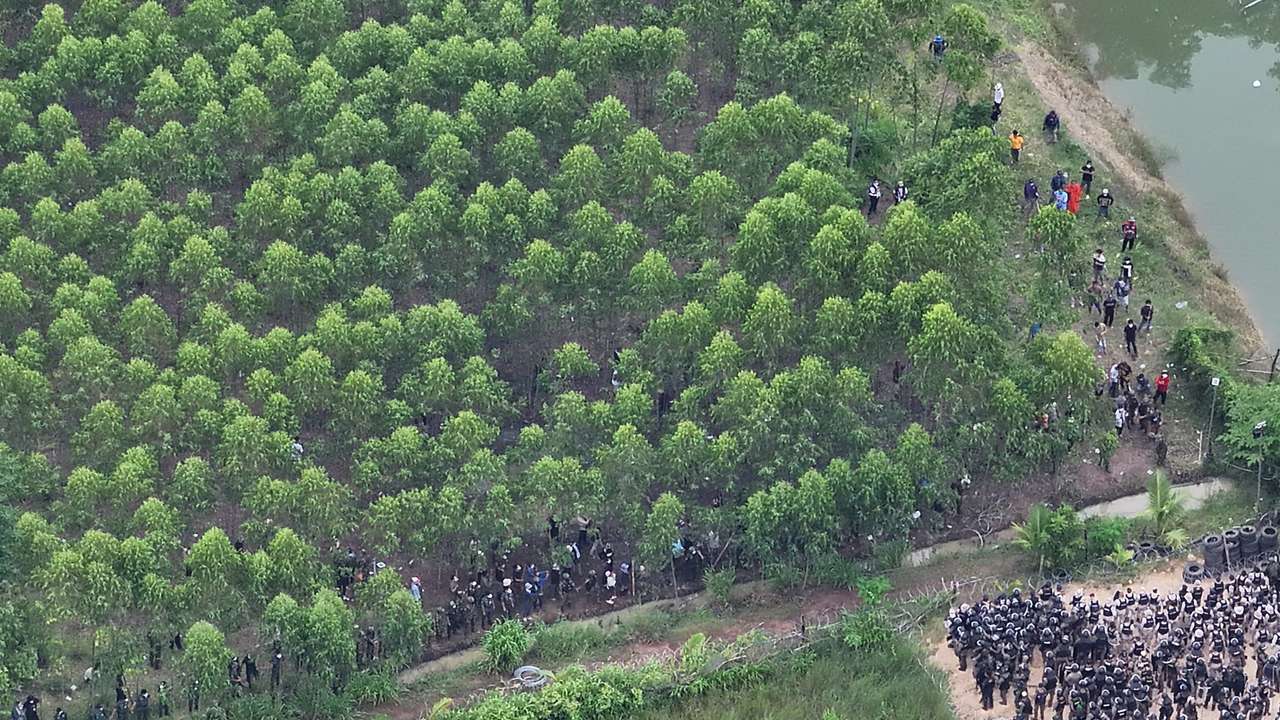A drone view shows Thai soldiers and riot police officers confronting Cambodian people in a disputed village along the Thailand-Cambodia border in Sa Kaeo province