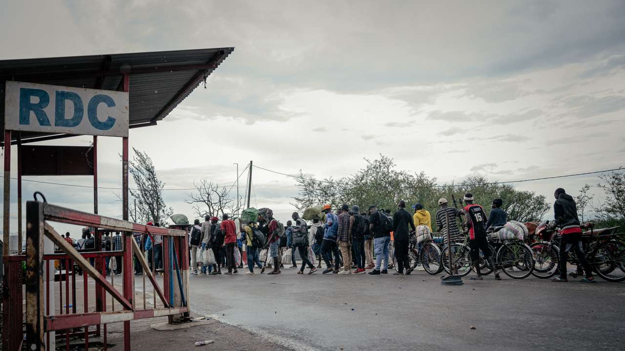 Displaced Burundian nationals line up with their belongings on the Congolese side as they attempt to cross into Burundi following the closure of the border between the Democratic Republic of Congo and Burundi at the Kavimvira border post on December 14, 2025.
