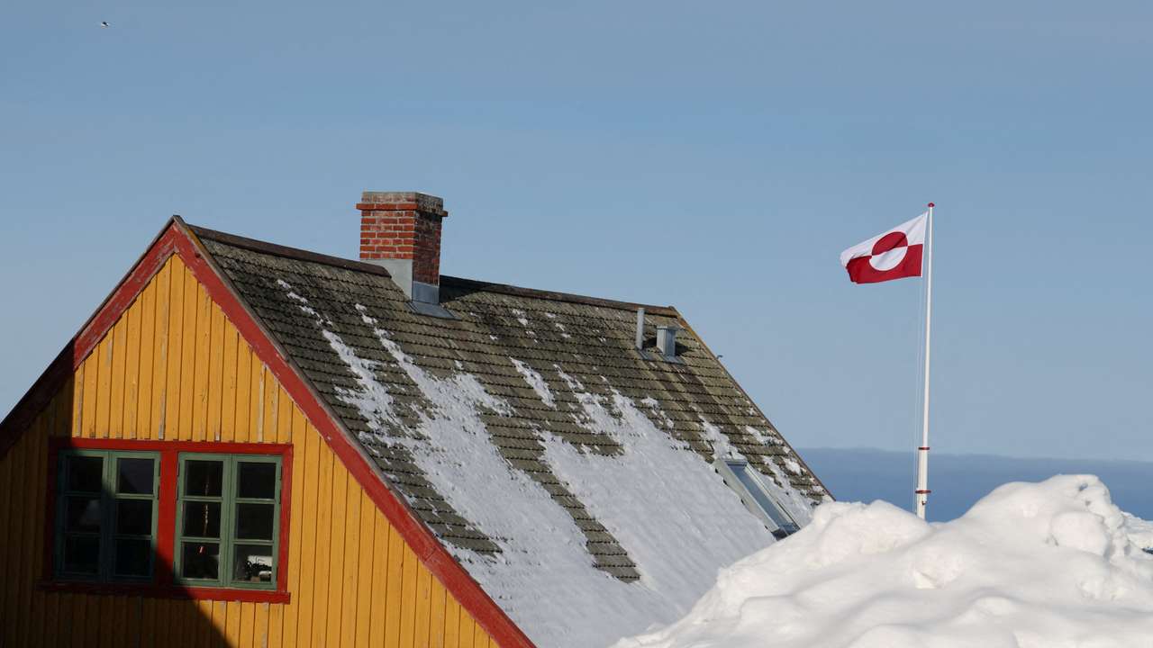 Greenland's national flag flutters next to a house in Nuuk