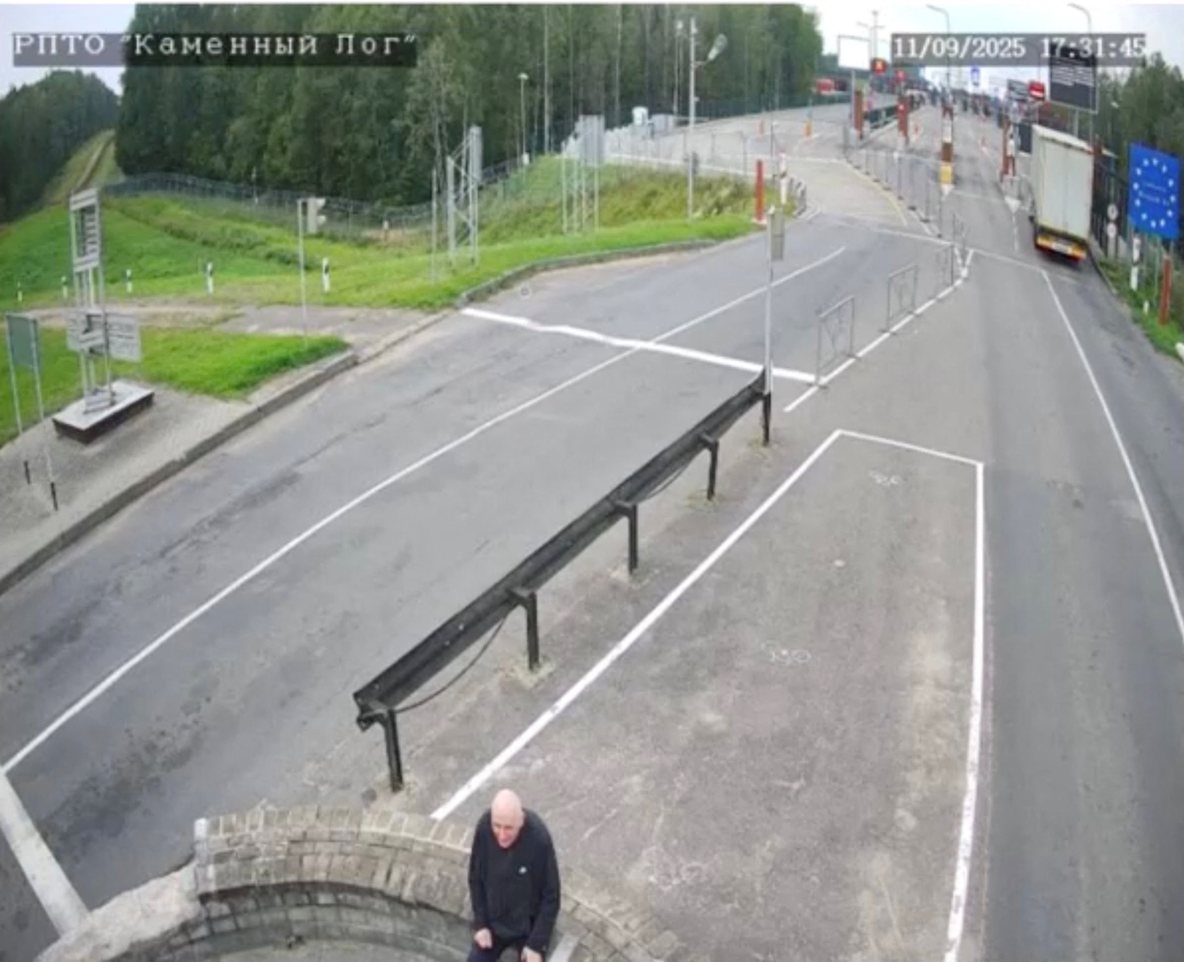 A man, believed to be Belarusian opposition politician Mikola Statkevich, sits in the no man's zone at the Lithuania border crossing