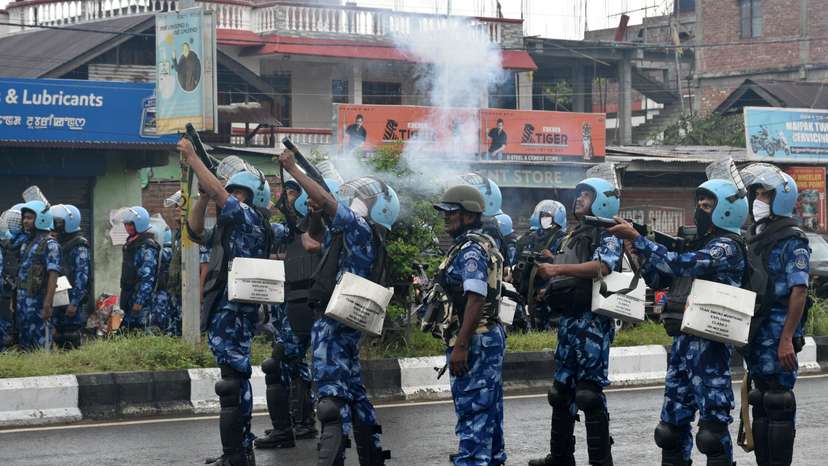 Riot police officers fire tear smoke shells to disperse demonstrators, in Imphal