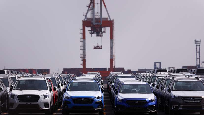 Newly manufactured cars awaiting export are parked at a port in Yokohama