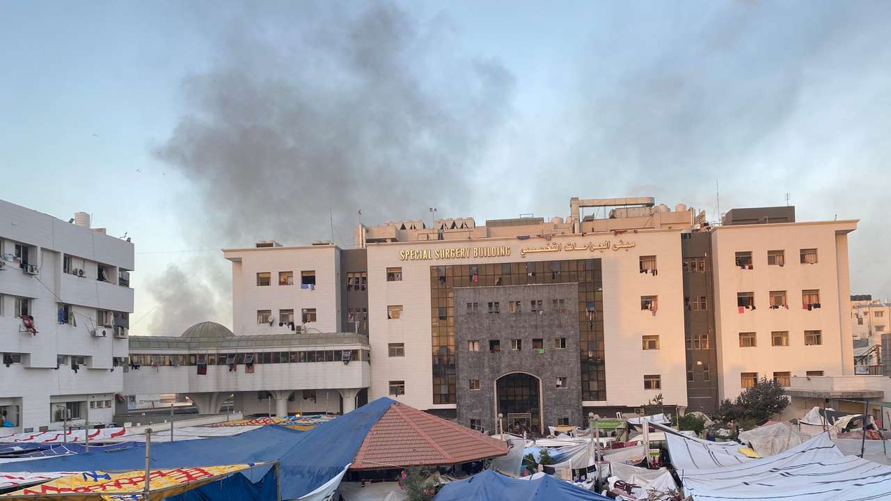 Smoke rises as displaced Palestinians take shelter at Al Shifa hospital, amid the ongoing conflict between Hamas and Israel, in Gaza City