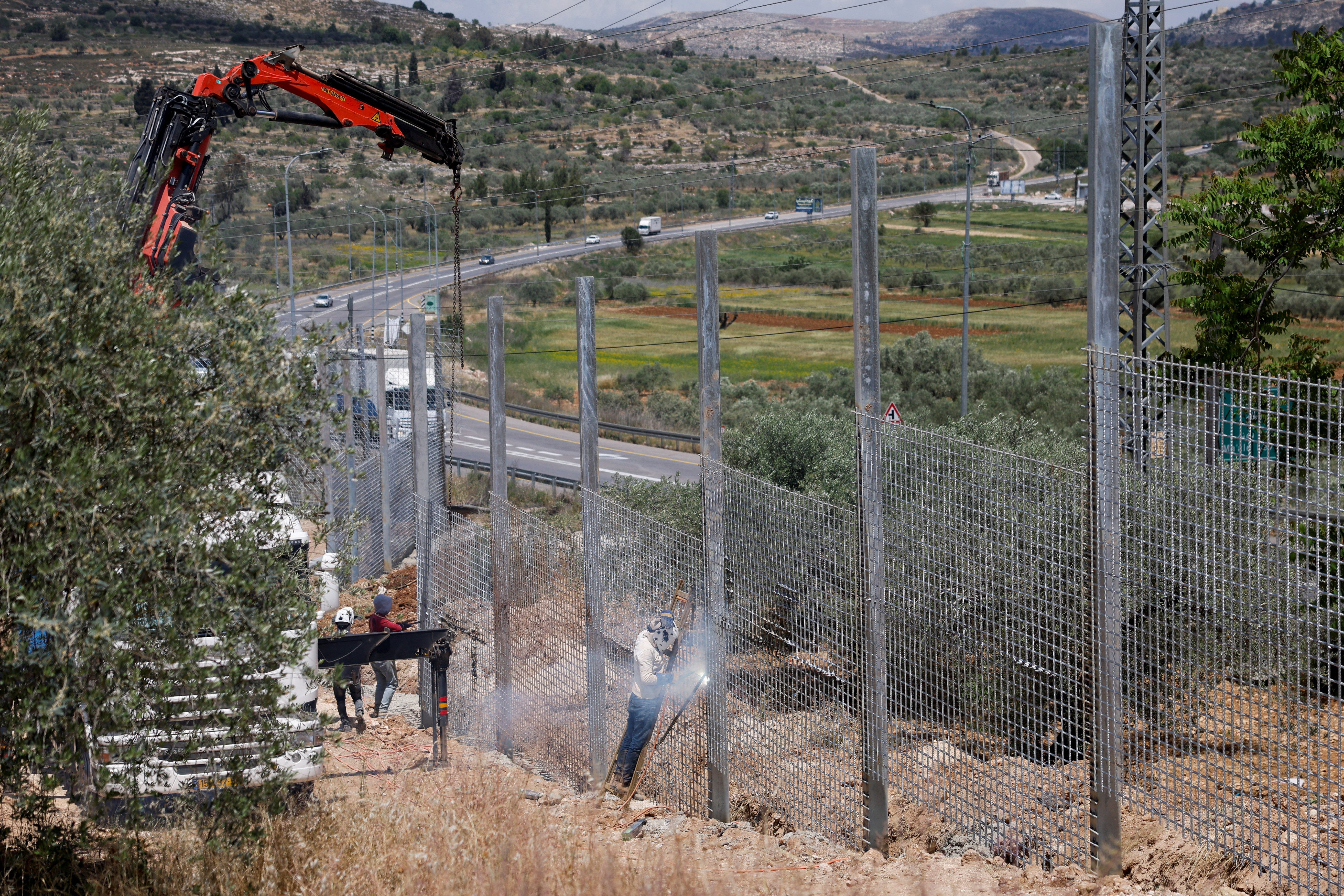 Israeli authorities encircle Palestinian town in West Bank with a fence, restricting free movement of residents