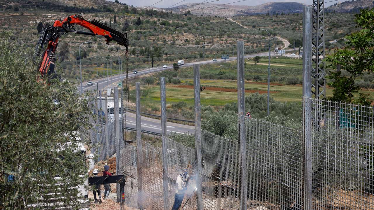 Israeli authorities encircle Palestinian town in West Bank with a fence, restricting free movement of residents