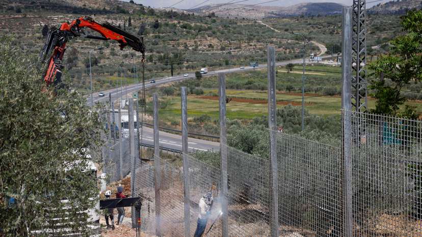 Israeli authorities encircle Palestinian town in West Bank with a fence, restricting free movement of residents