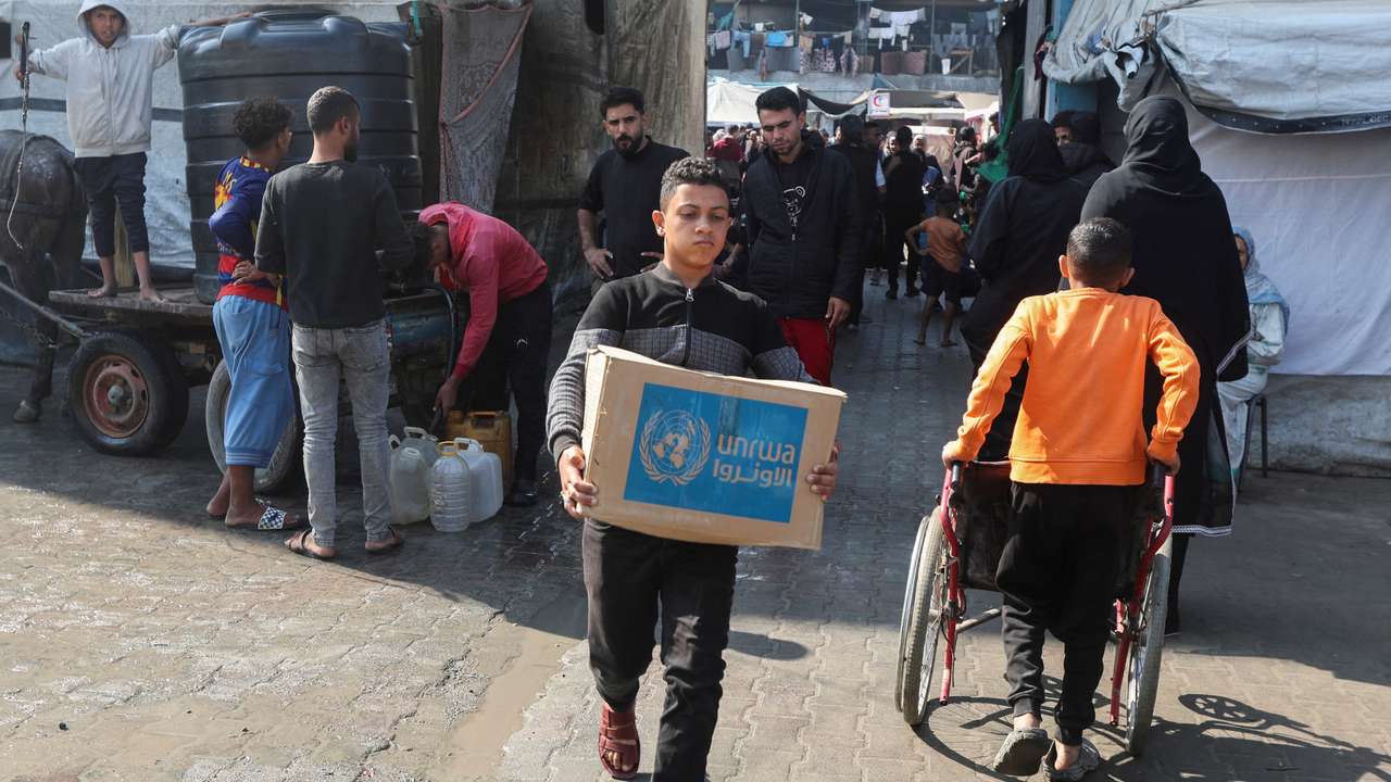 FILE PHOTO: Palestinians receive aid from UNRWA in Deir Al-Balah, central Gaza Strip