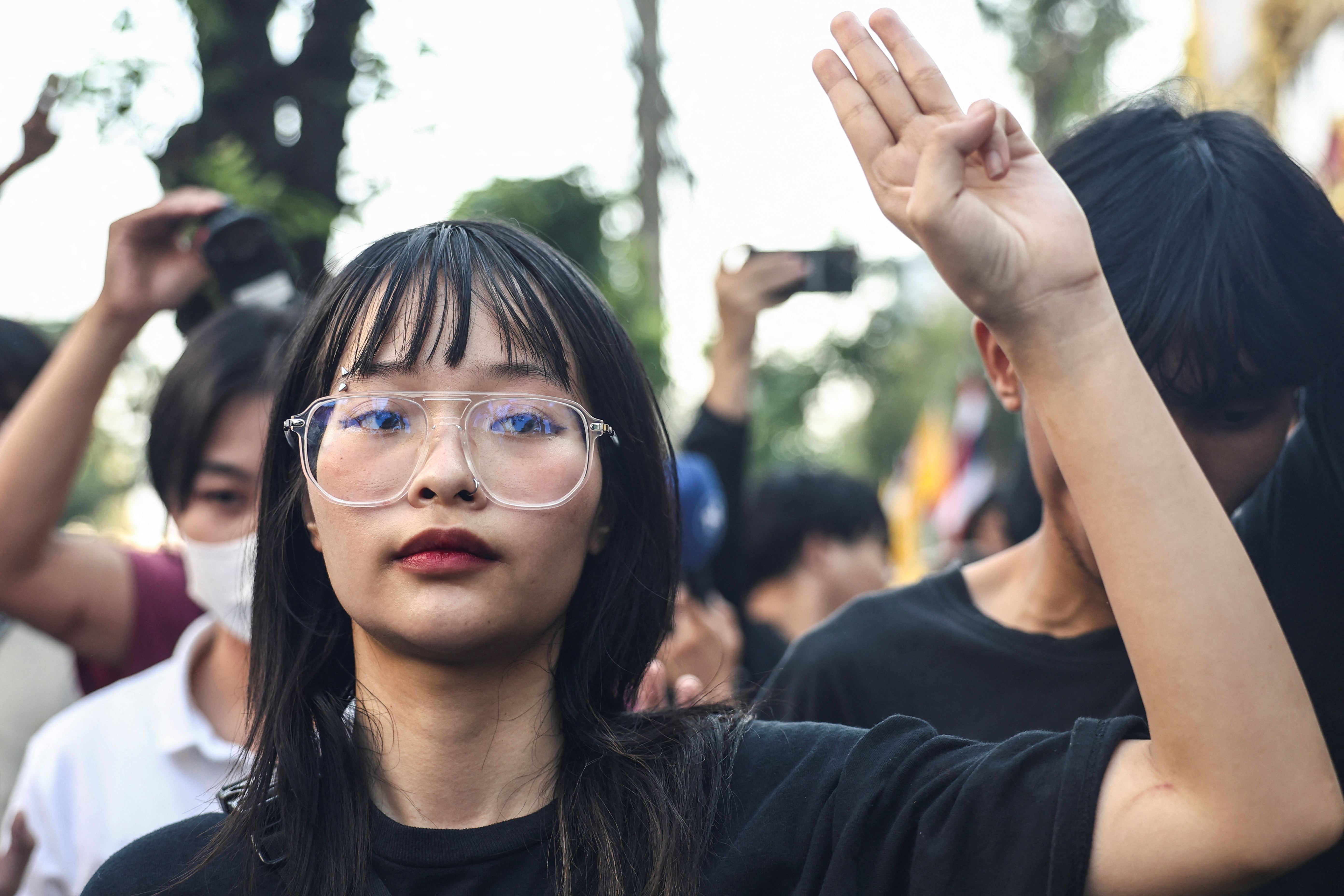 Thai monarchy reform activist Tantawan "Tawan" Tuatulanon shows a three-finger salute as she is arrested for sedition and related charges outside a criminal court in Bangkok