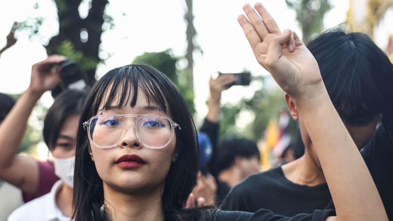 Thai monarchy reform activist Tantawan "Tawan" Tuatulanon shows a three-finger salute as she is arrested for sedition and related charges outside a criminal court in Bangkok