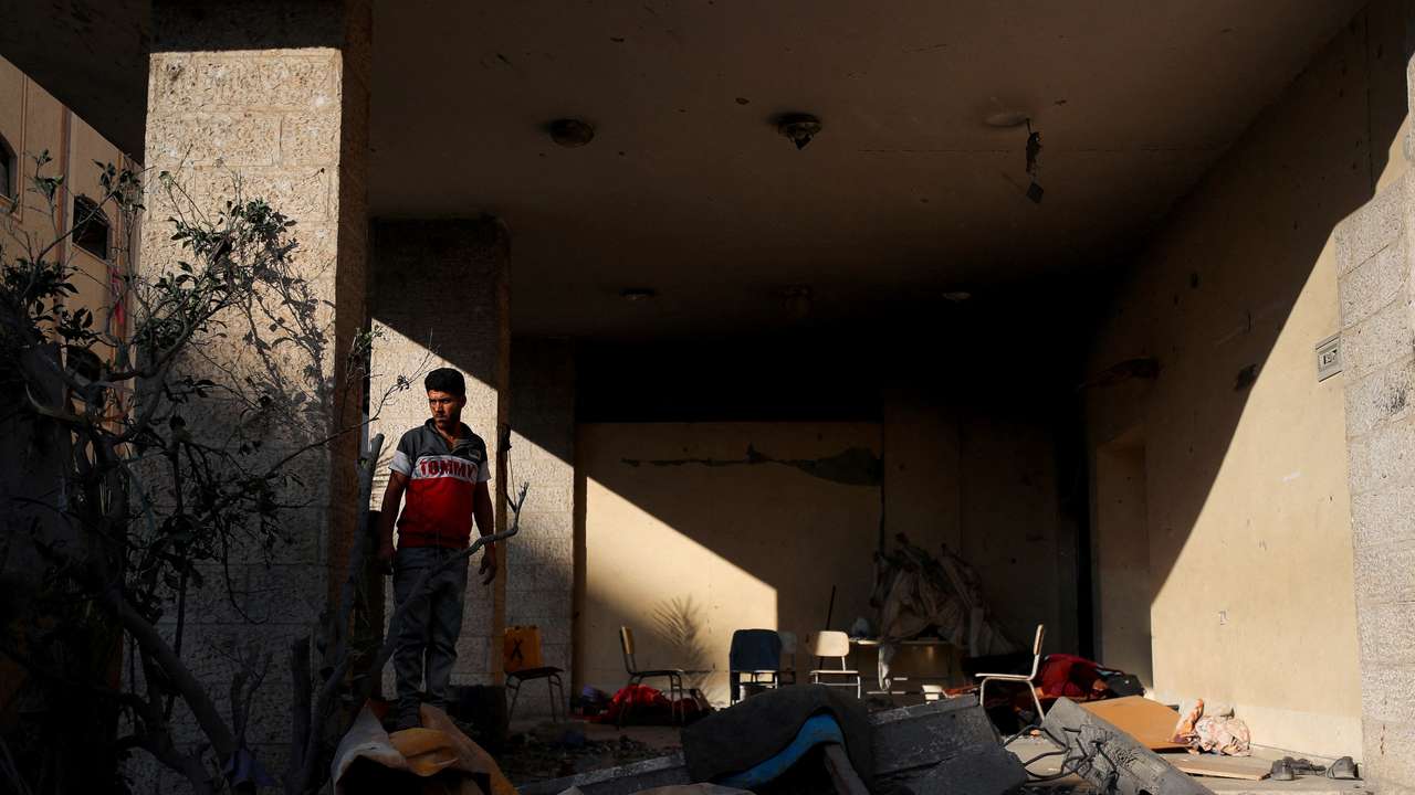 Palestinians inspect the site of an overnight Israeli strike on a house, in Gaza City