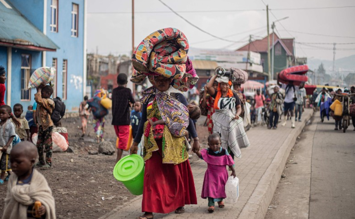 A woman carries a mattress and other belongings on her head as she flees from Kibati, where fighting has intensified, towards the city of Goma