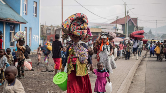 A woman carries a mattress and other belongings on her head as she flees from Kibati, where fighting has intensified, towards the city of Goma