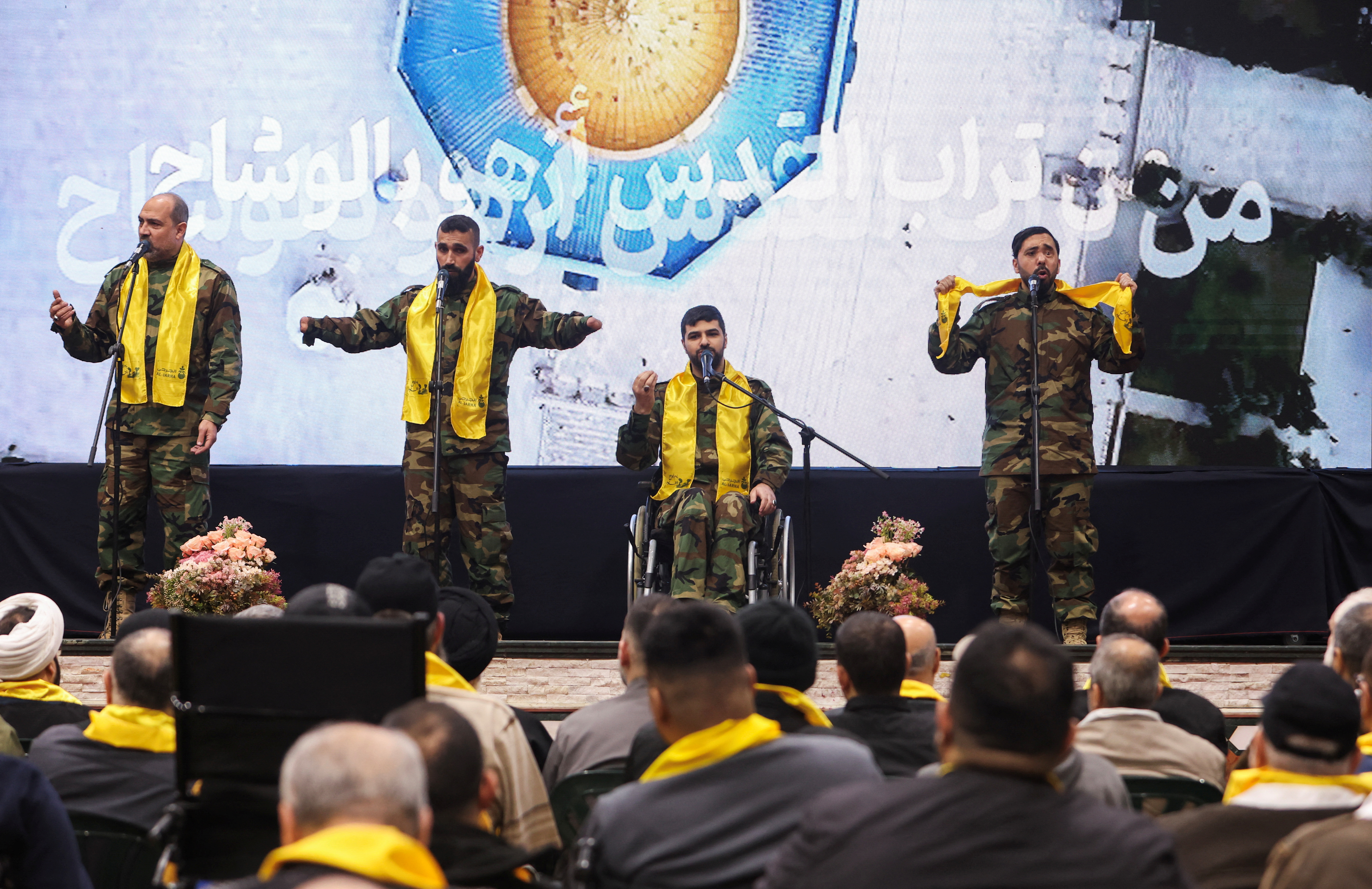 Hezbollah veterans perform on stage before Lebanon's Hezbollah leader Sayyed Hassan Nasrallah addresses his supporters via a screen during a rally in Beirut's southern suburbs