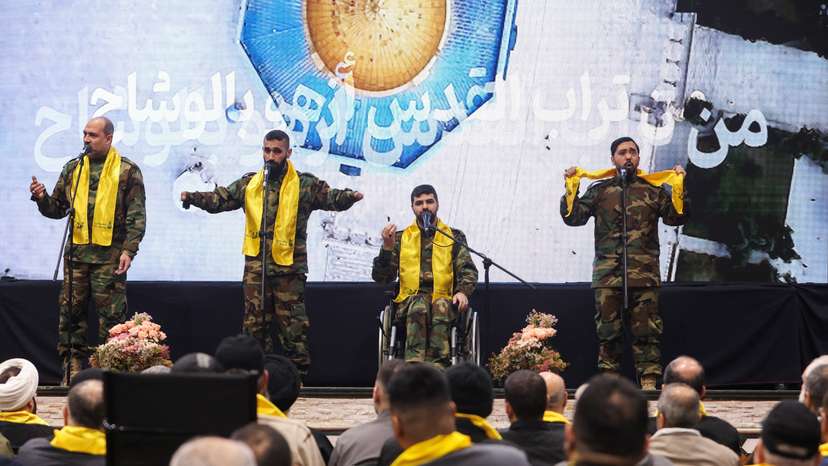 Hezbollah veterans perform on stage before Lebanon's Hezbollah leader Sayyed Hassan Nasrallah addresses his supporters via a screen during a rally in Beirut's southern suburbs
