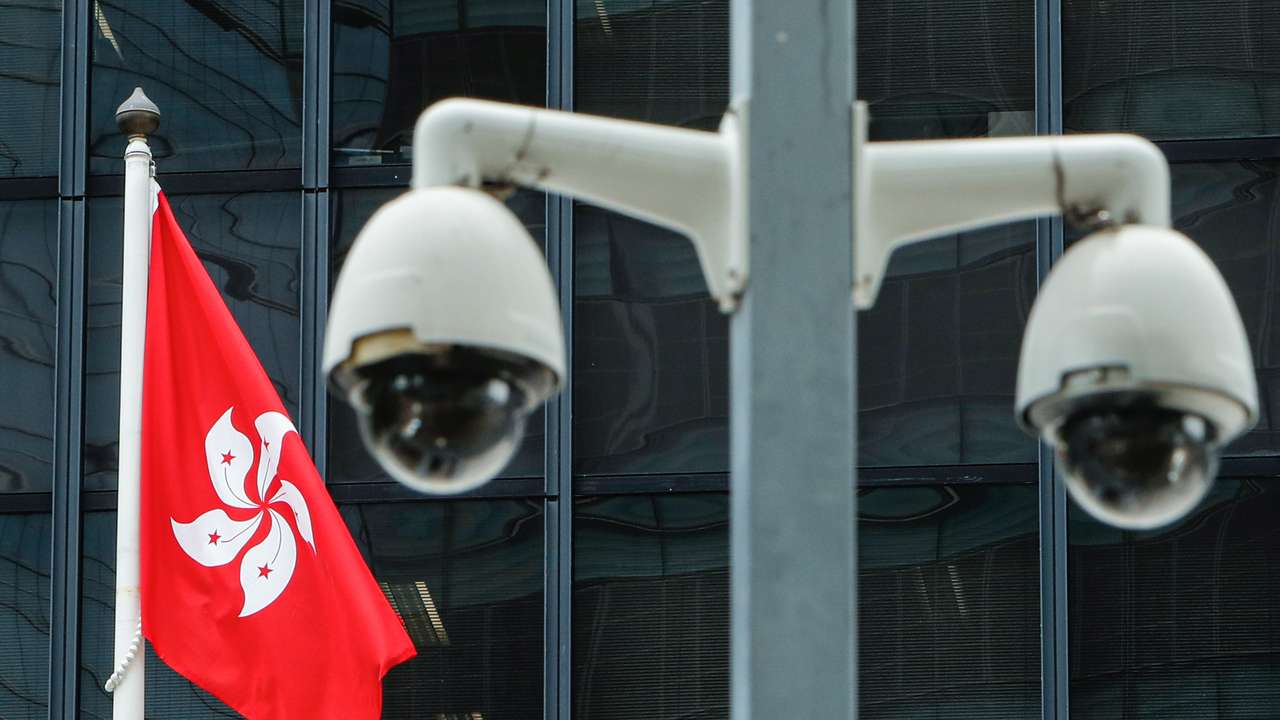 A Hong Kong flag is flown behind a pair of surveillance cameras outside the Central Government Offices in Hong Kong