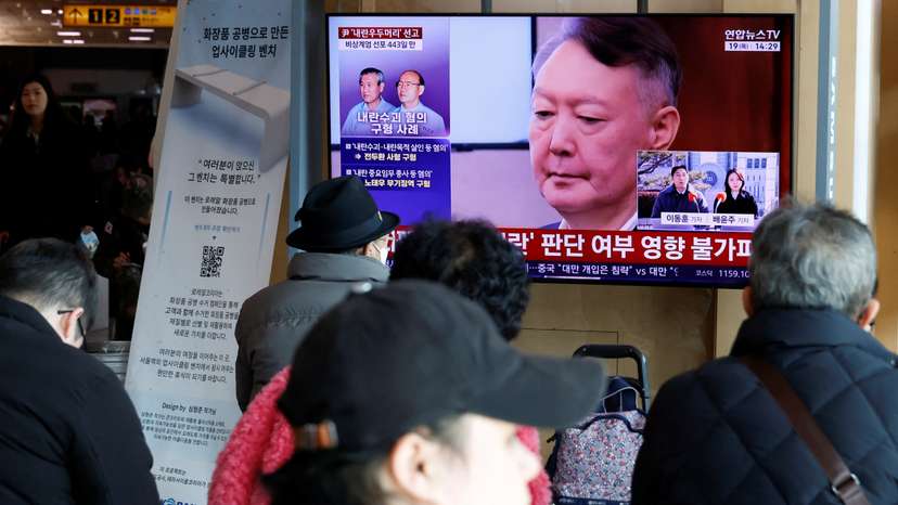 People watch a news report on the sentencing trial of South Korean former president Yoon Suk Yeol's insurrection case in Seoul