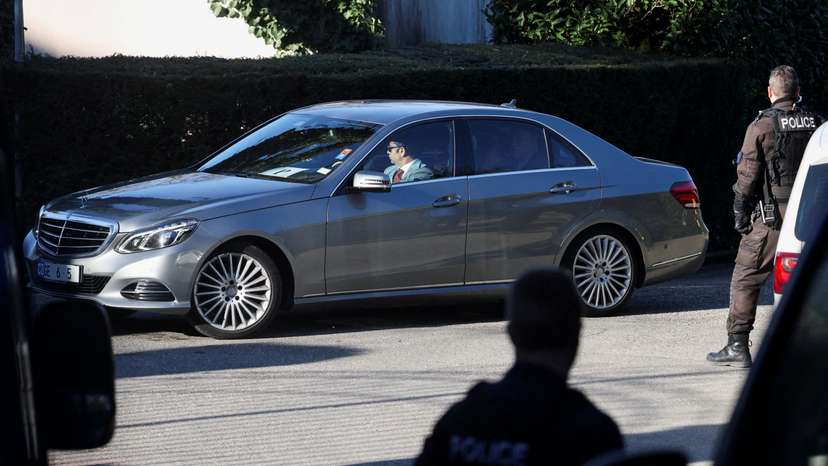 Police officers stand guard as a diplomatic car drives near the residence of the Omani ambassador to the United Nations, in Cologny