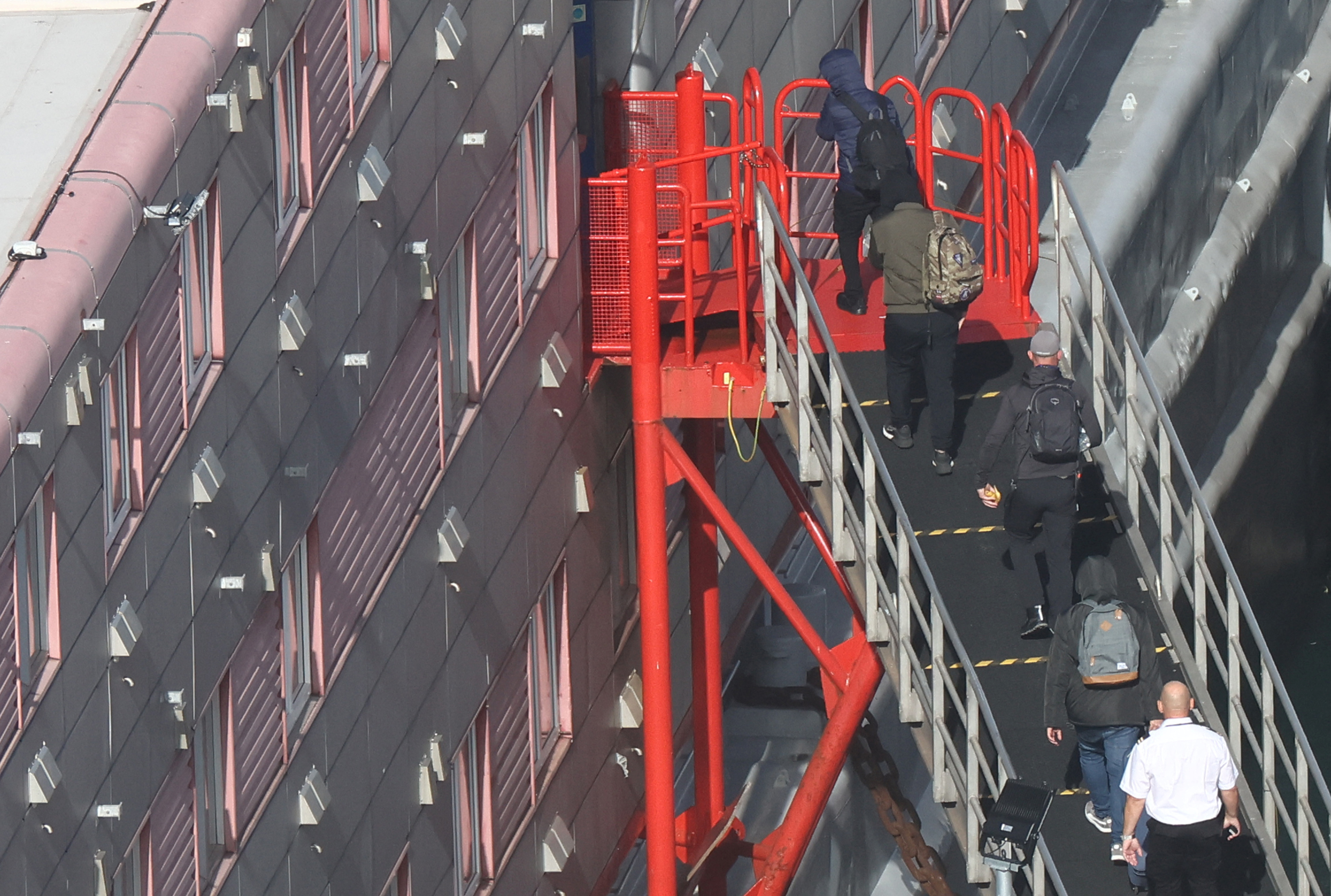 People, believed to be asylum seekers, arrive to be housed on the Bibby Stockholm accommodation barge at Portland Port, Portland near Weymouth