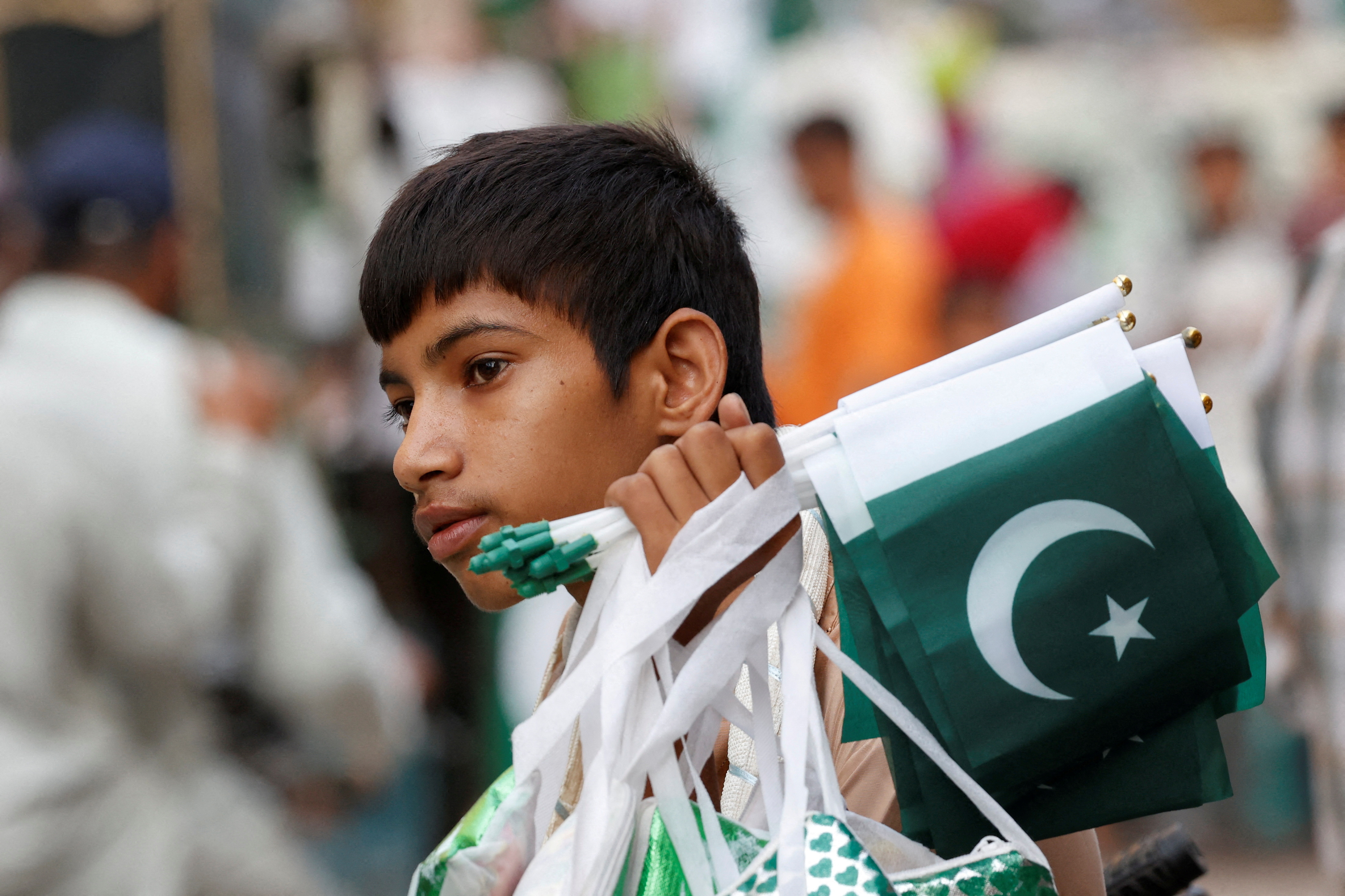 FILE PHOTO: Young man sells national flags and patriotic memorabilia, ahead of Pakistan's Independence Day, in Karachi