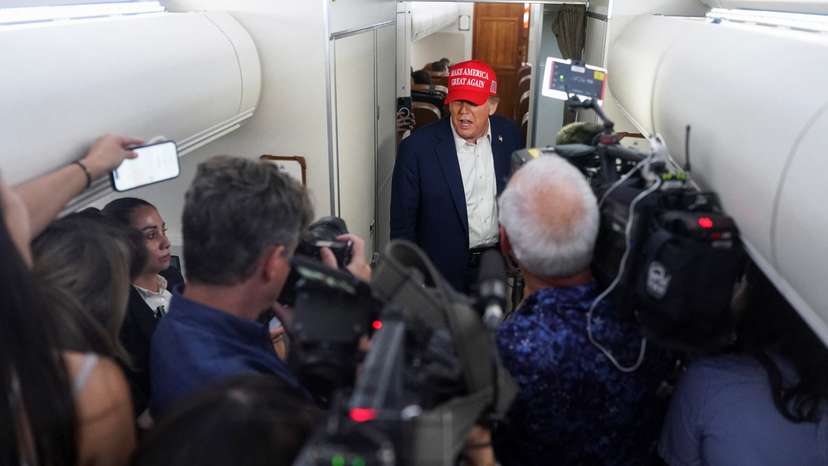 U.S. President Donald Trump speaks to members of the media on board Air Force One on the way to New Jersey
