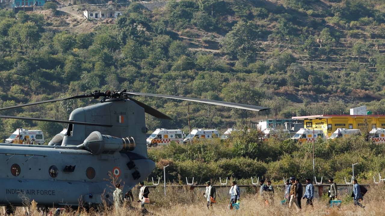 Workers, who were rescued from a tunnel which collapsed in Uttarkashi, walk to board an Indian Air Force's Chinook helicopter to be airlifted to AIIMS Rishikesh hospital, in Chinyalisaur