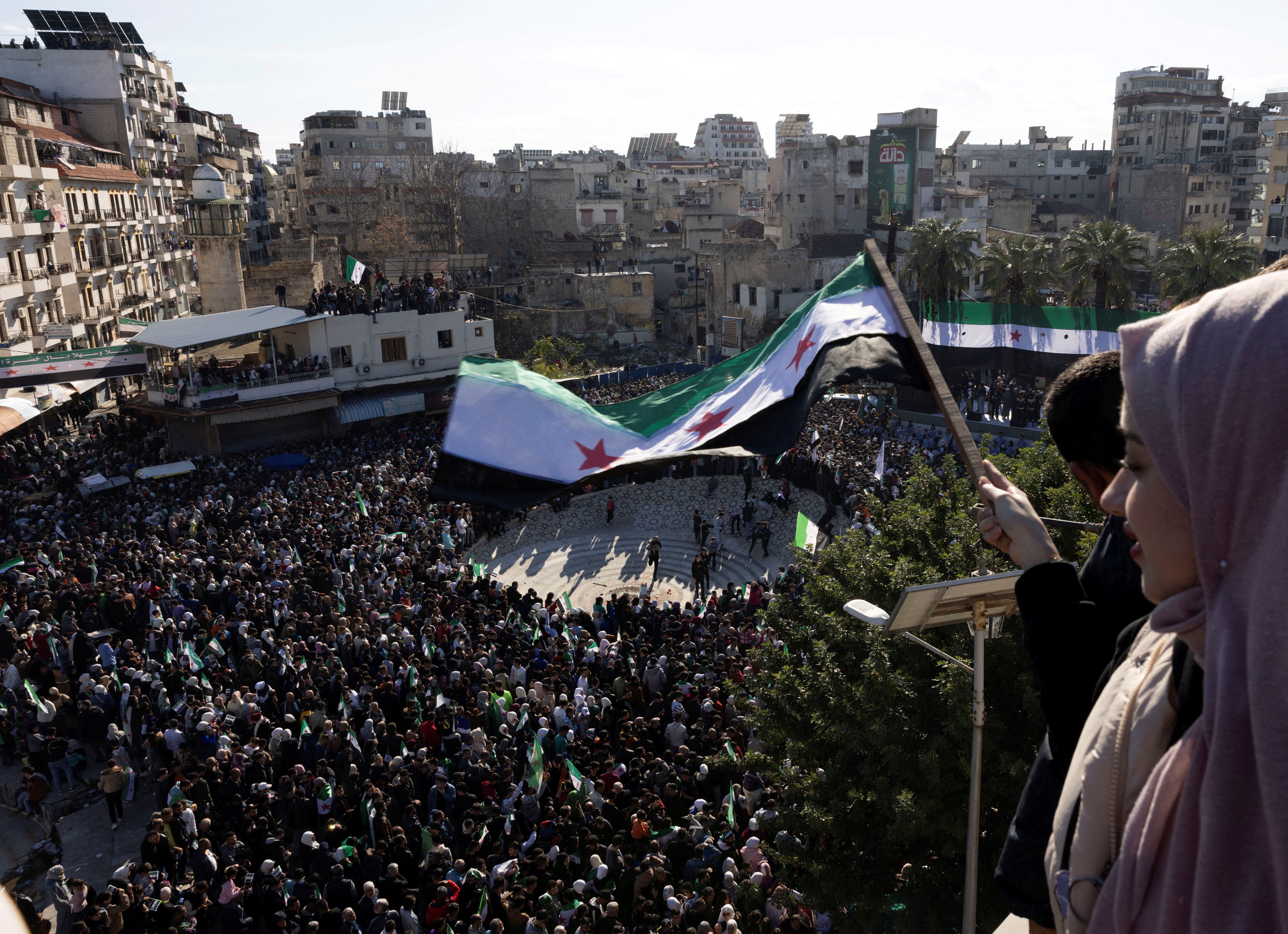 People celebrate after the ousting of Syria's Bashar al-Assad, during a gathering after friday prayers in Latakia