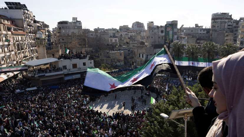People celebrate after the ousting of Syria's Bashar al-Assad, during a gathering after friday prayers in Latakia