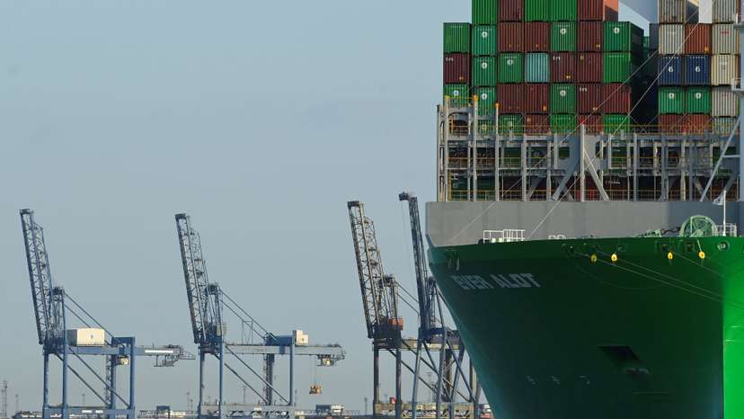 A container ship is docked next to cranes at UK's biggest container port Felixstowe in Felixstowe
