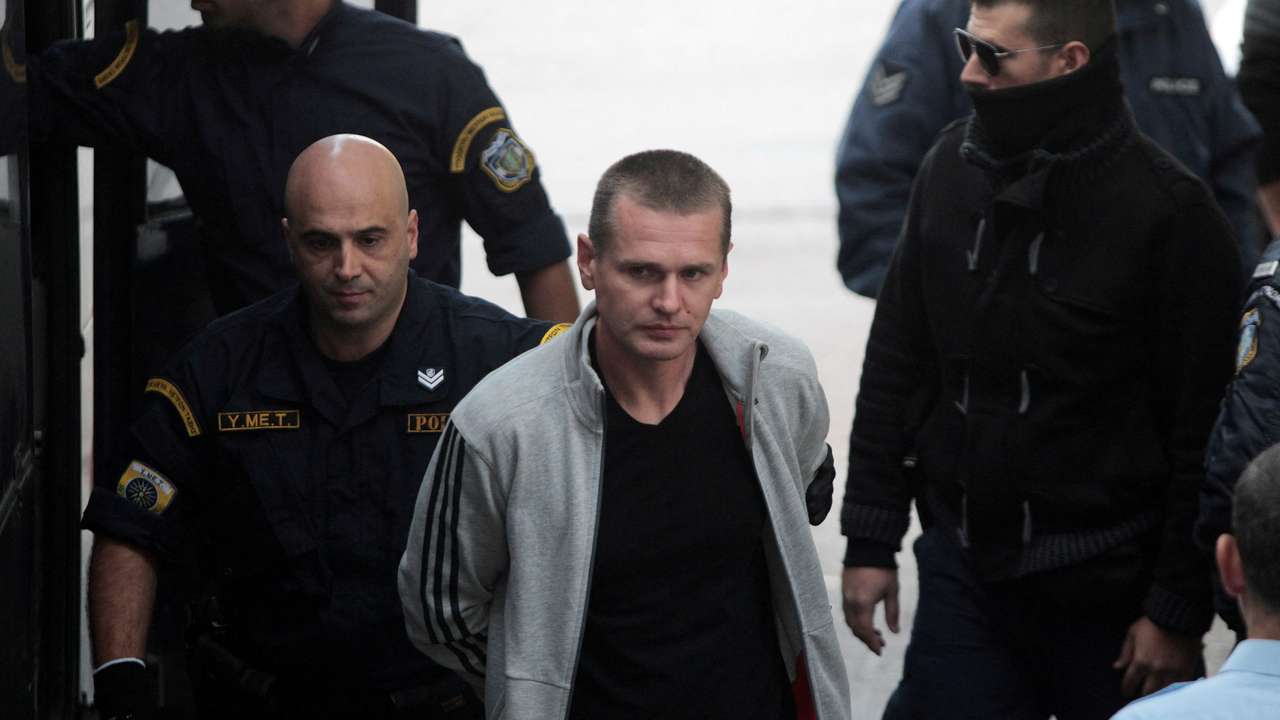 FILE PHOTO: Alexander Vinnik, a 38 year old Russian man suspected of running a money laundering operation using bitcoin, is escorted by police officers to a court in Thessaloniki
