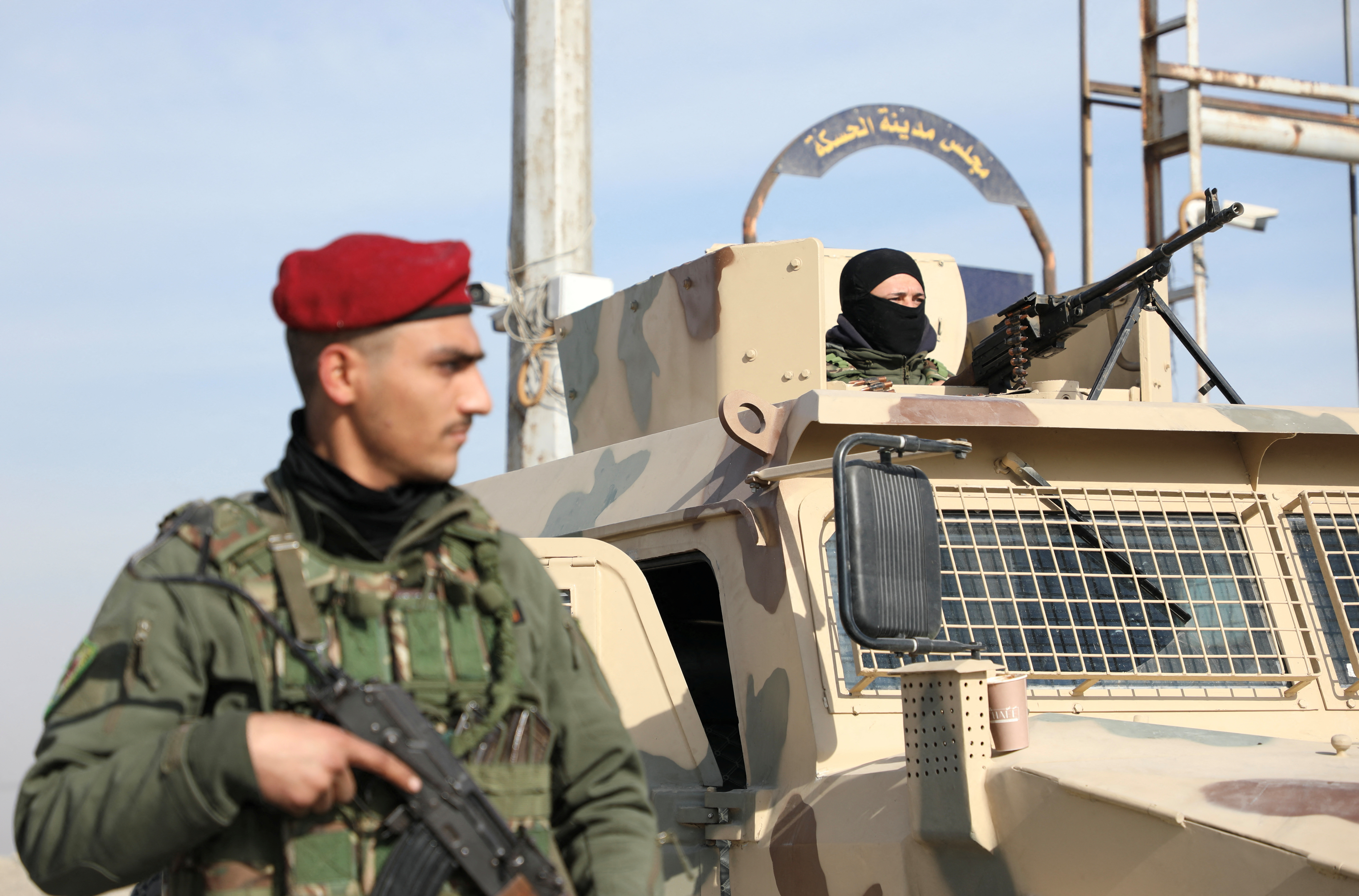 Member of Kurdish-led Syrian Democratic Forces (SDF) stands along a street, in Hasakah