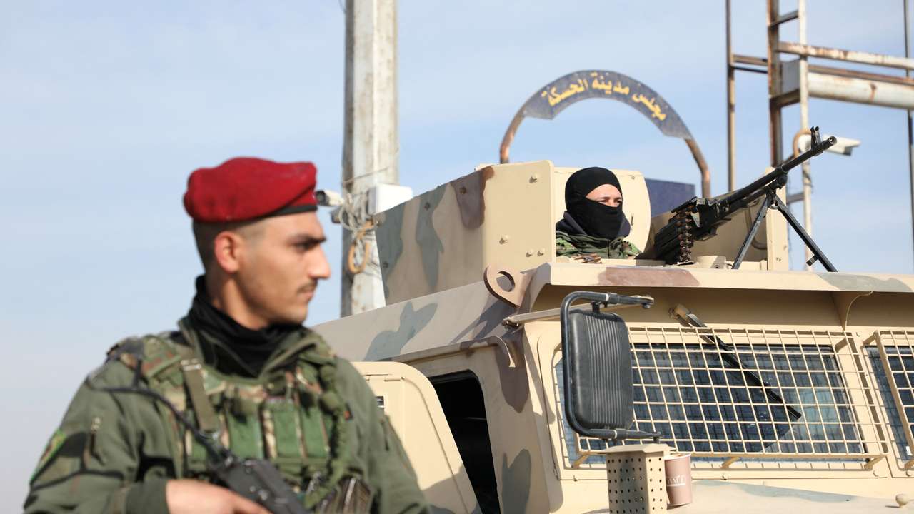 Member of Kurdish-led Syrian Democratic Forces (SDF) stands along a street, in Hasakah