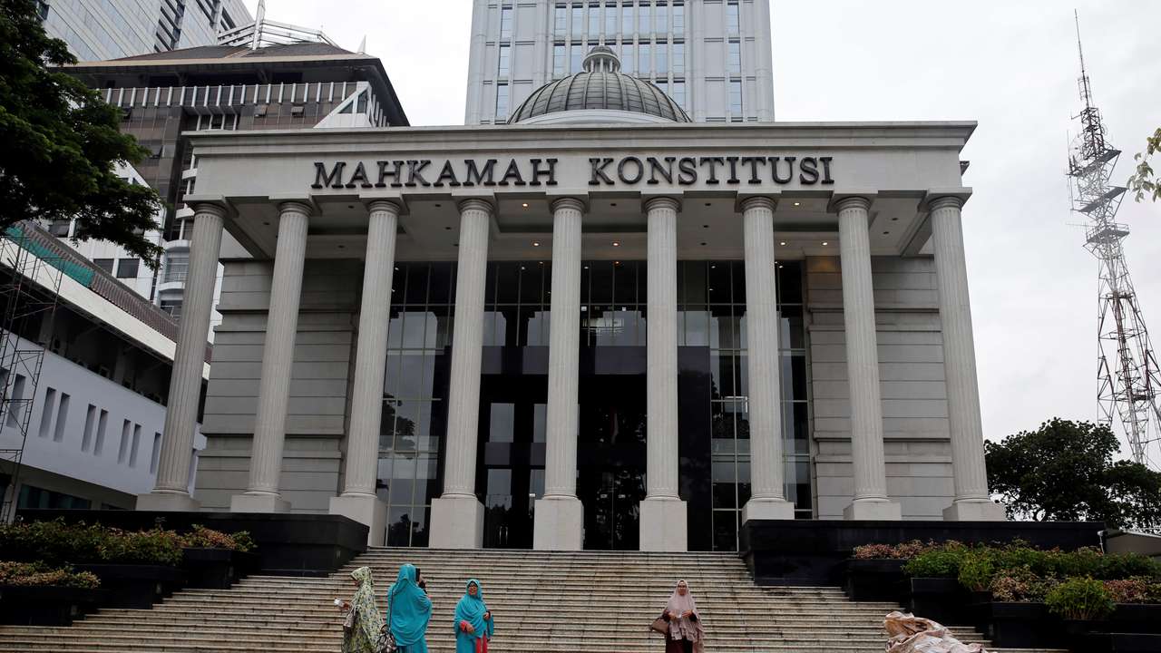 Muslim women walk in front of Indonesia's constitutional court after attending a trial in Jakarta