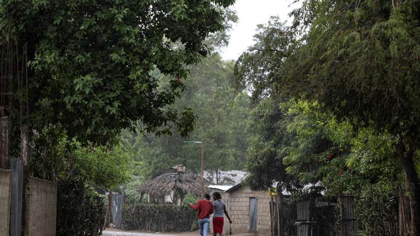 Women walk under the rain in the Malfety neighborhood of Fort Liberte
