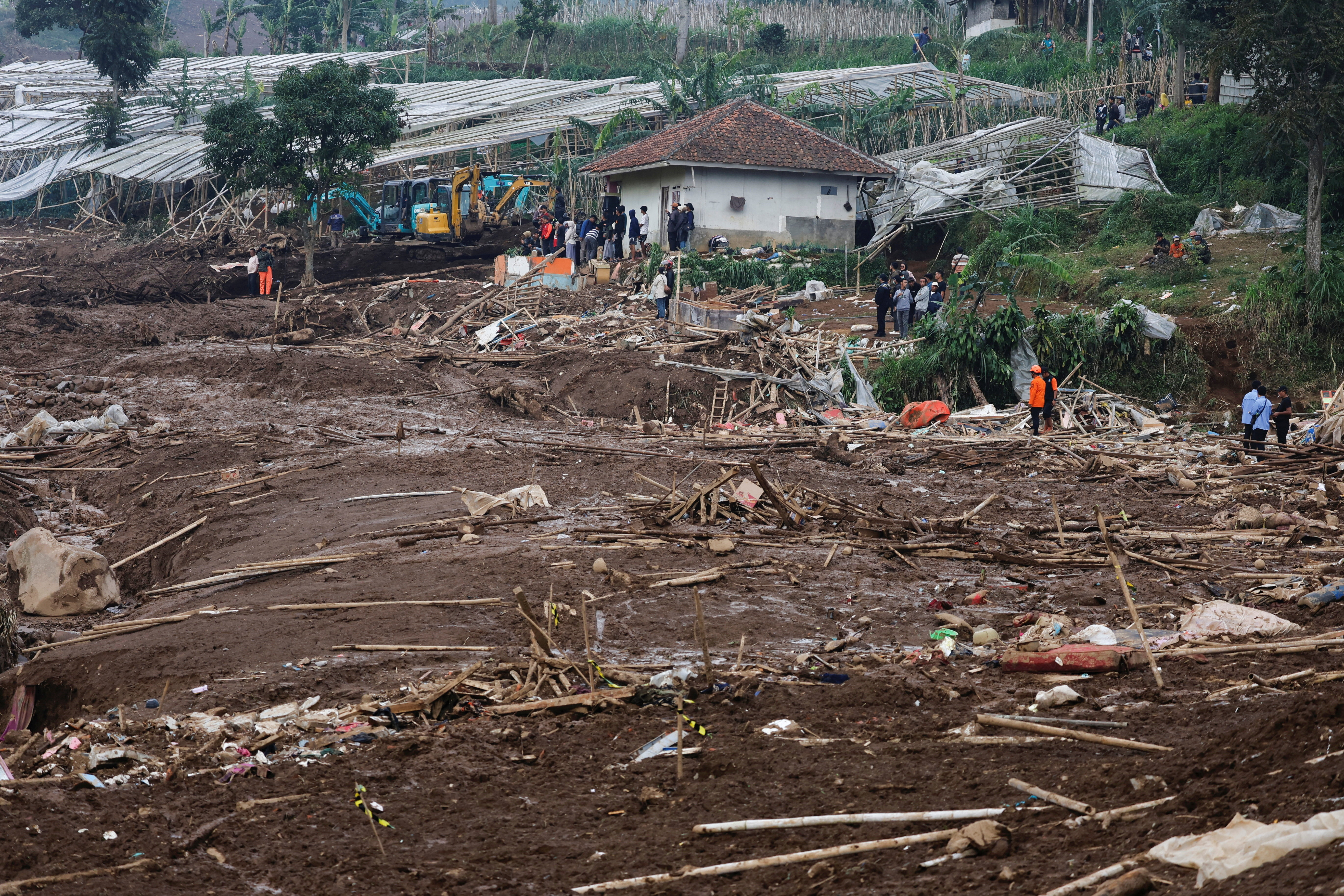 Locals stand in an area affected by landslides following heavy rains in Pasir Langu village, West Bandung