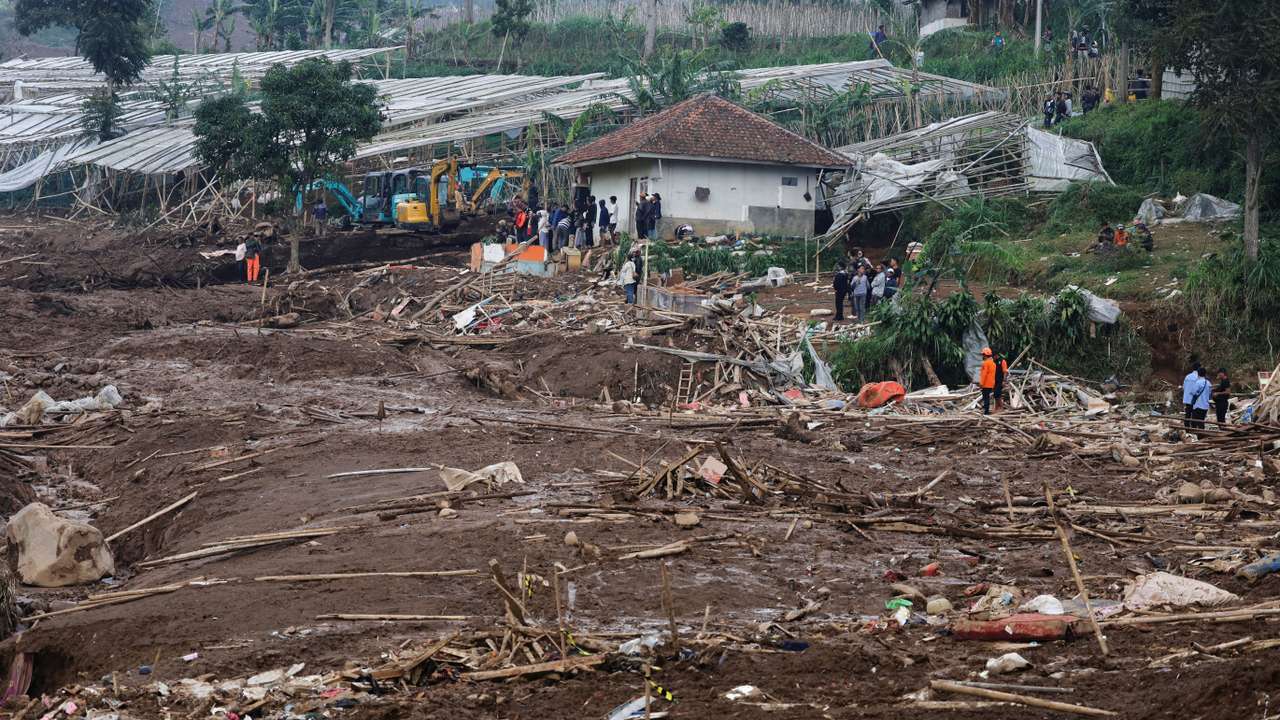 Locals stand in an area affected by landslides following heavy rains in Pasir Langu village, West Bandung
