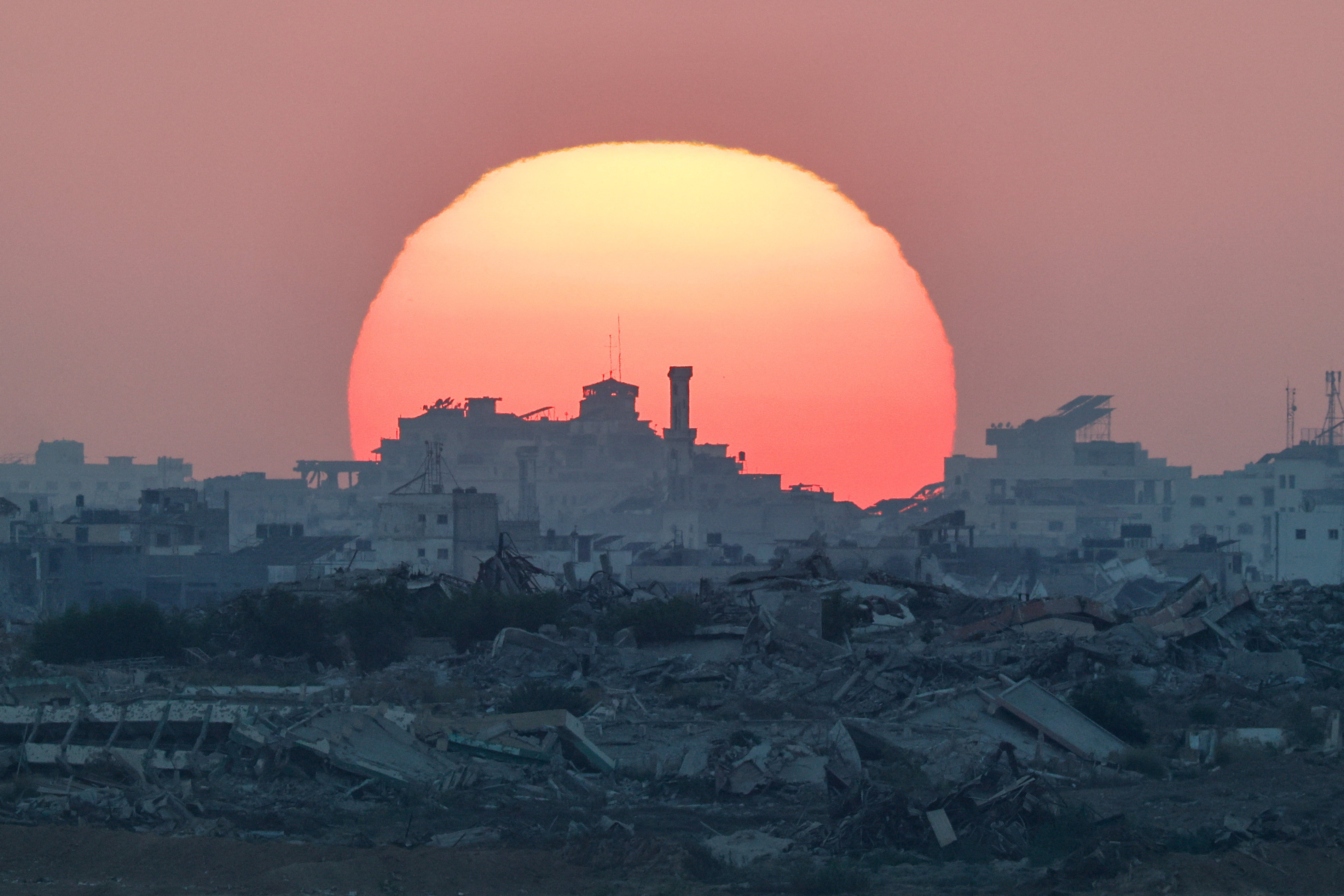 The sun sets over Gaza, as seen from the Israeli side of the border between Gaza and Israel