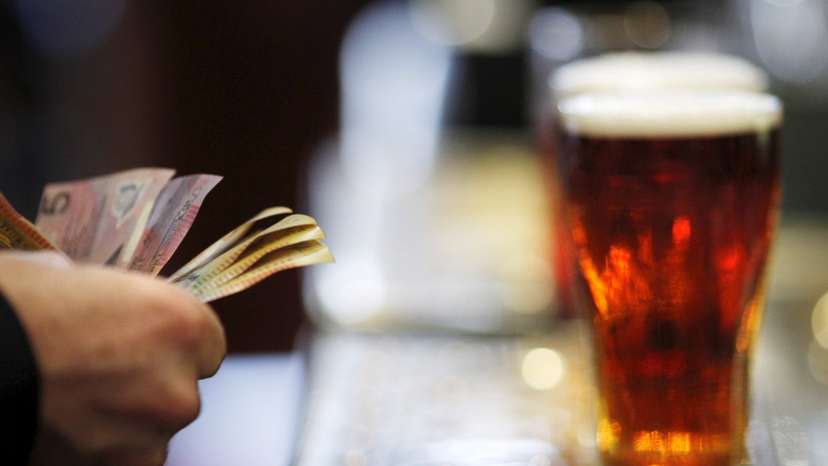 File photo of a customer paying for a Fosters beer at the Occidental Hotel in central Sydney