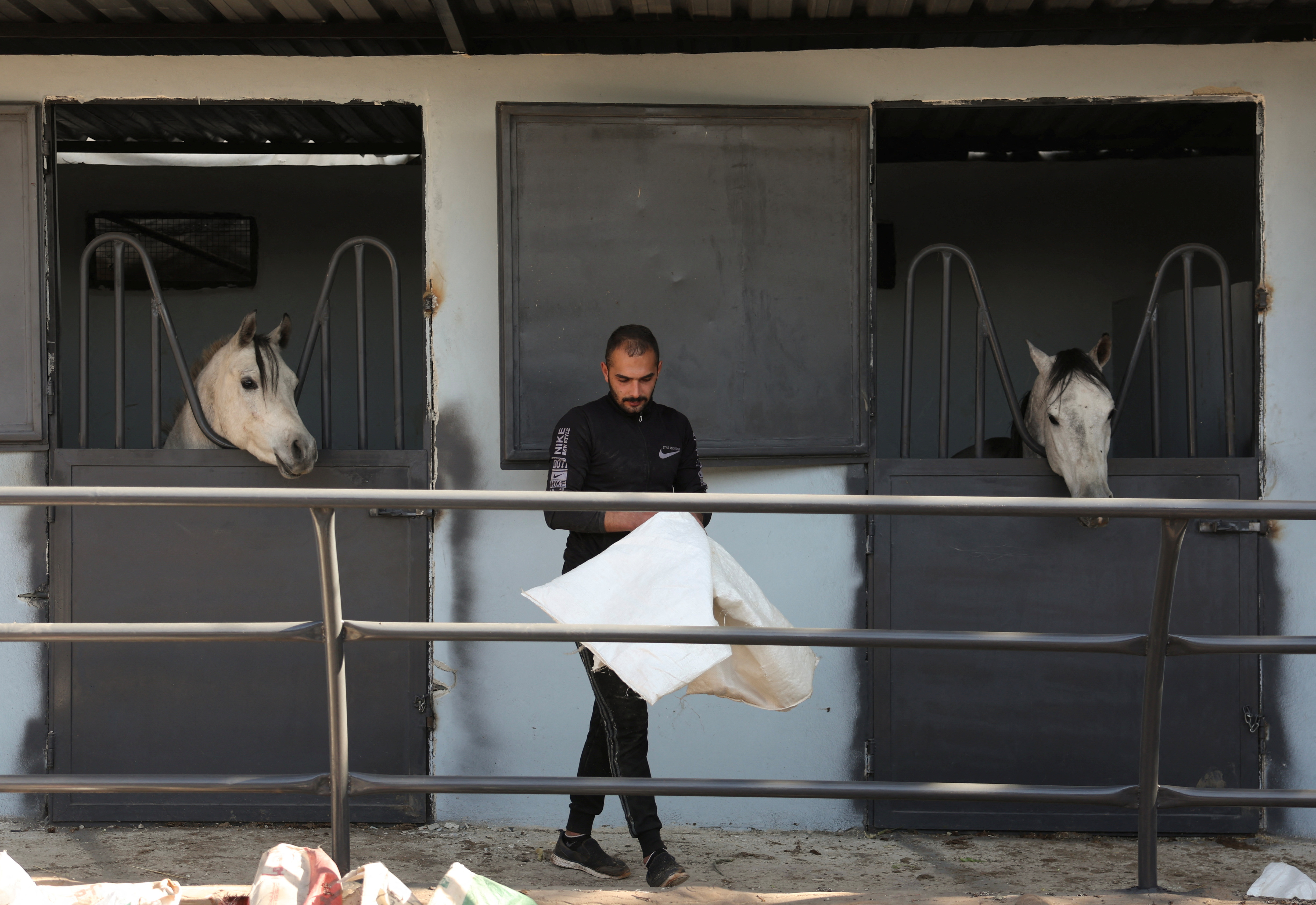 Farhan al-Khouli, Syrian military conscript who deserted his post on the first day of the rebel offensive, walks at a horse stable in Damascus