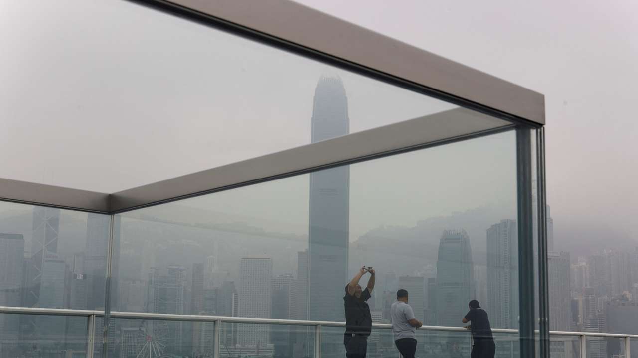 People take photos at the waterfront during a foggy day in Hong Kong