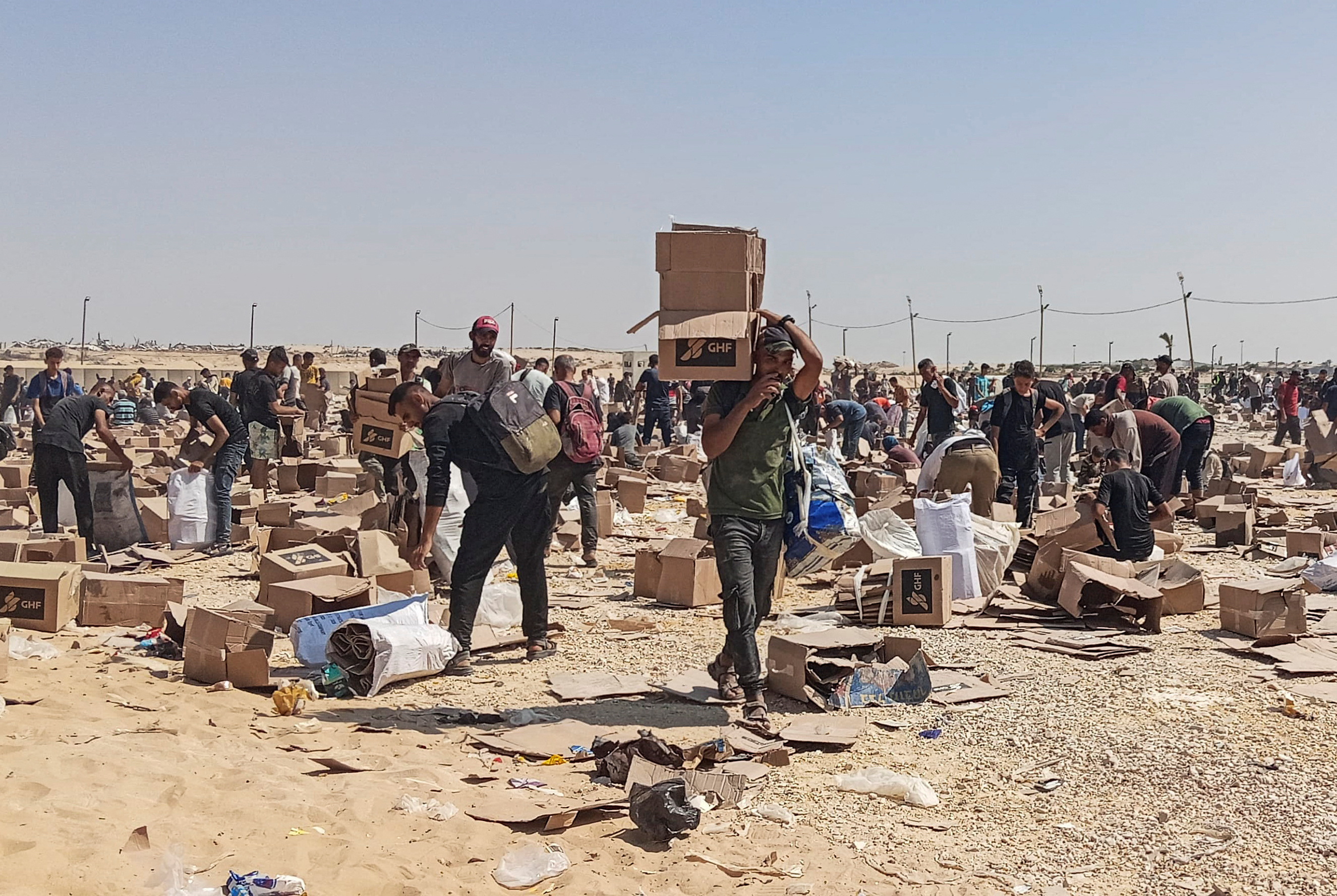 Palestinians gather to collect what remains of relief supplies of the U.S.-backed Gaza Humanitarian Foundation, in Rafah