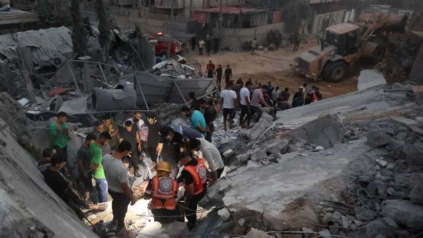 Palestinians search for casualties at the site of Israeli strikes on a residential building