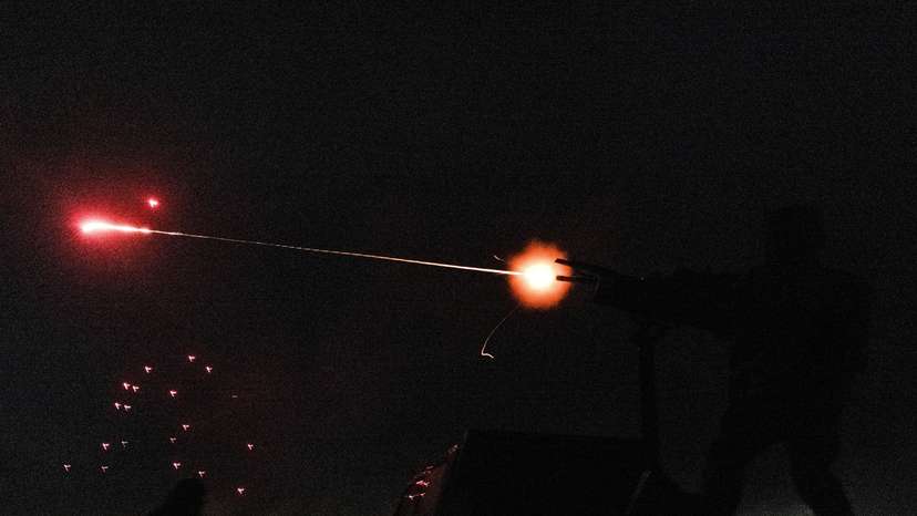 Members of a mobile air defence volunteer unit fire machine gun and an assault rifle to shoot down an unmanned aerial vehicle during the most massive Russian drone attack in Kyiv region