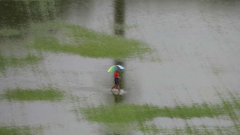 A man walks through floodwater as rain pours in Kuala Lumpur