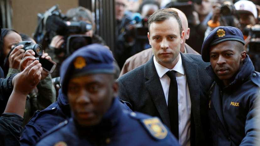 FILE PHOTO: Olympic and Paralympic track star Oscar Pistorius is escorted by police officers as he arrives for his sententencing for the 2013 murder of his girlfriend Reeva Steenkamp, at North Gauteng High Court in Pretoria