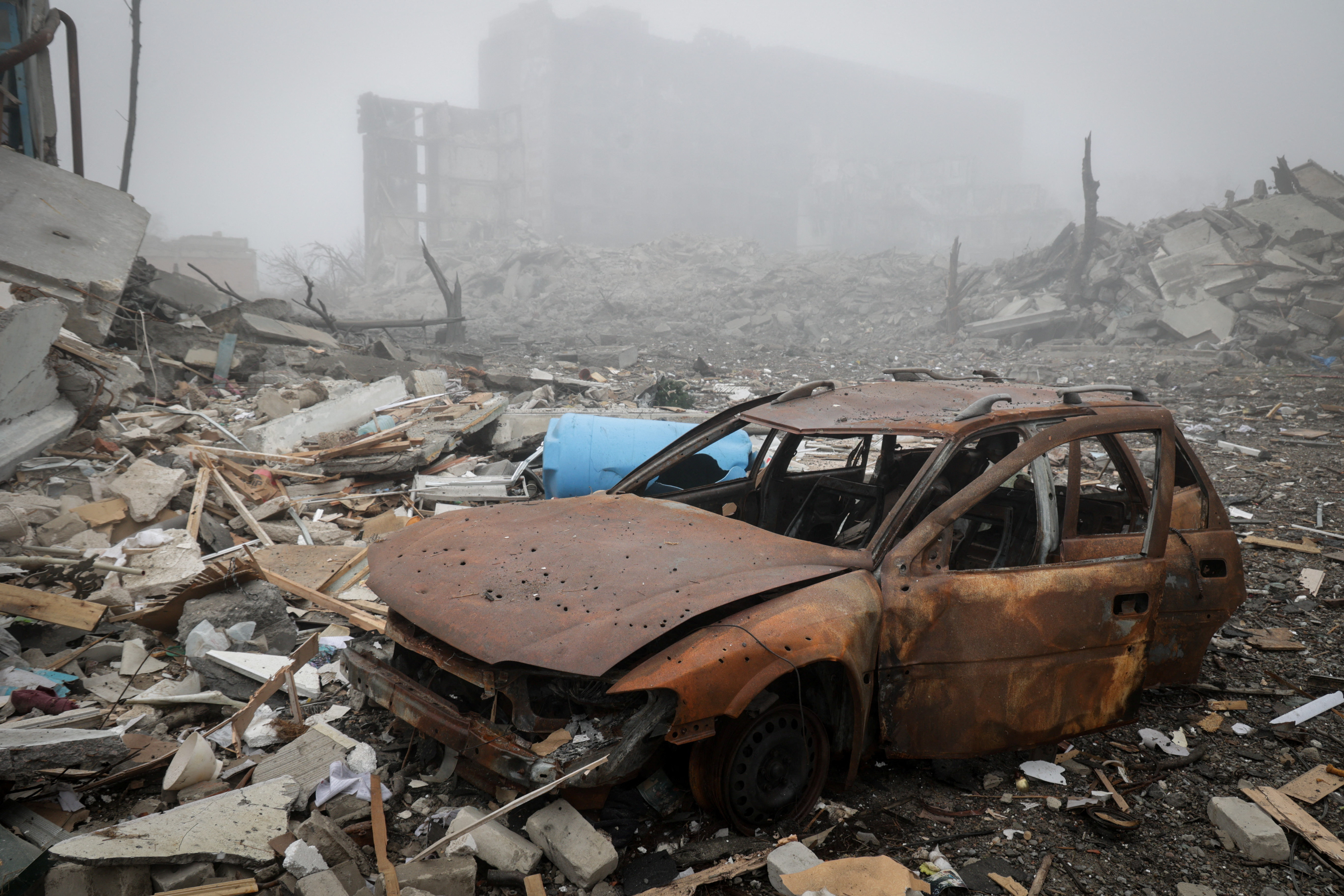 A destroyed car near apartment buildings damaged by Russian military strike in the frontline town of Kostiantynivka