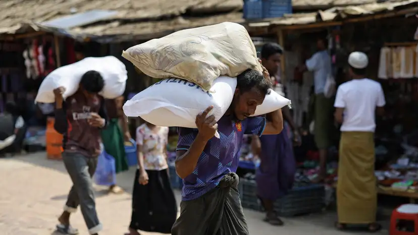 Rohingya refugees carry relief supplies after receiving them from a distribution centre at a refugee camp in Cox's Bazar