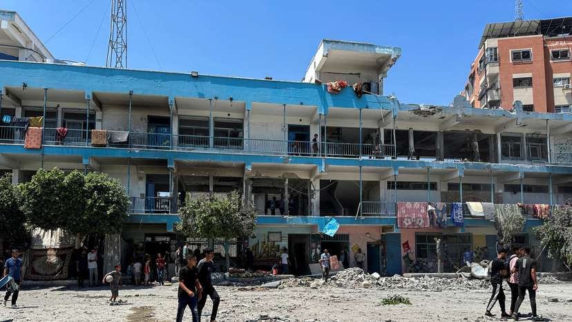 Palestinians inspect the site of an Israeli strike on a UNRWA school sheltering displaced people, in Nuseirat refugee camp