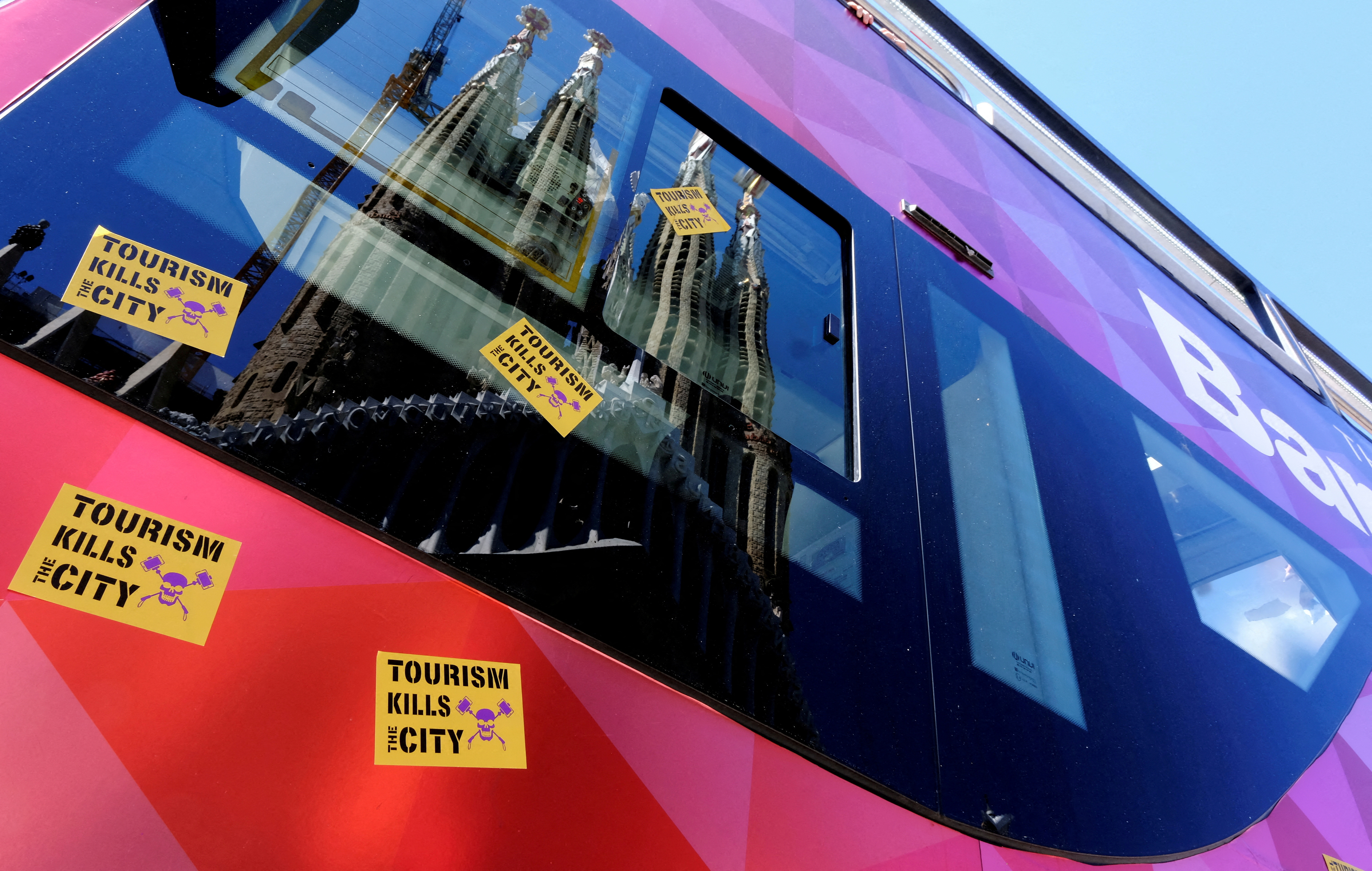 FILE PHOTO: Stickers that read "Tourism kills the City" are stuck on a Tourist City Sightseeing bus during a protest against mass tourism in Barcelona