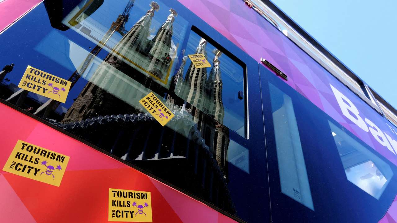 FILE PHOTO: Stickers that read "Tourism kills the City" are stuck on a Tourist City Sightseeing bus during a protest against mass tourism in Barcelona