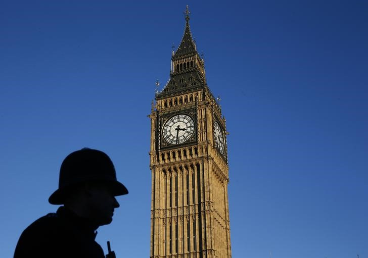 FILE PHOTO: A police officer is silhouetted against the sky next to the Big Ben clock tower during sunset in central London